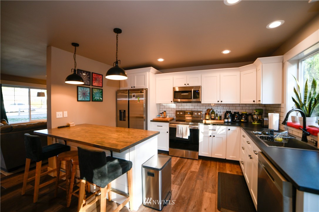 202 St Helens Way Winlock, WA 98596 - Photo 5 of 25 a kitchen with stainless steel appliances granite countertop wooden floor sink stove and refrigerator