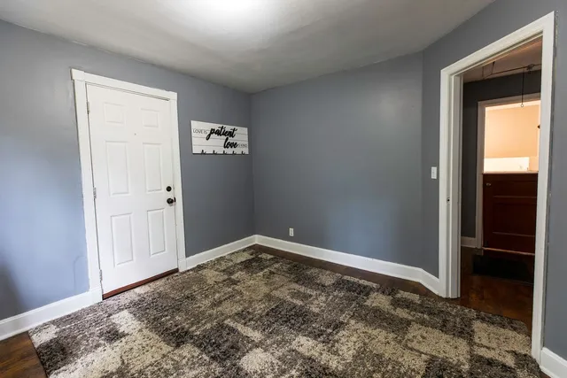 a living room with a dresser and a window