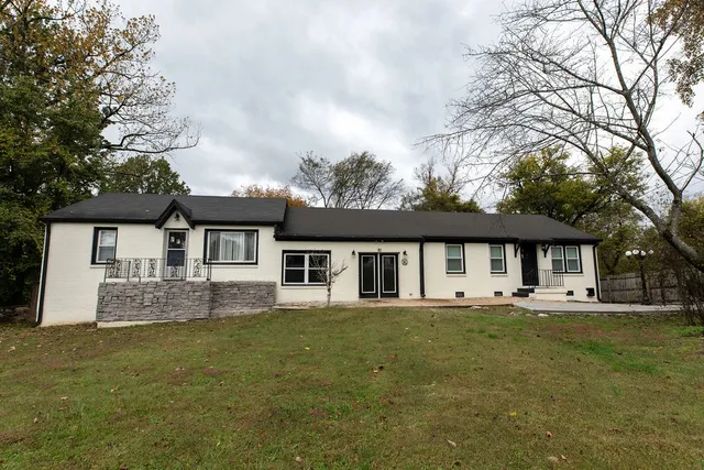 a front view of house with yard and trees around