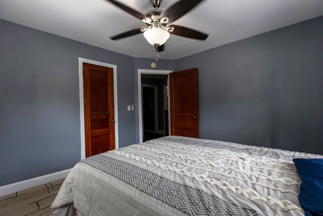 a bedroom with a large bed and a chandelier