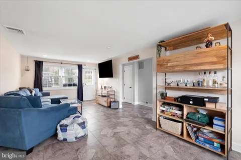 a living room with furniture a flat screen tv and a window