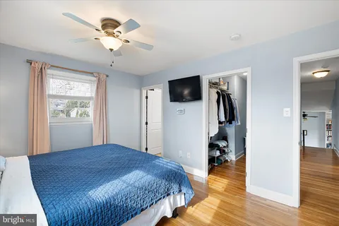 a spacious bedroom with a bed and a flat screen tv