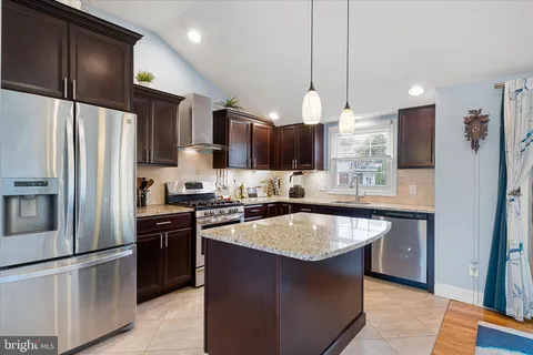 a kitchen with kitchen island a counter top space appliances and cabinets