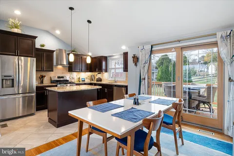 a kitchen with a dining table chairs and refrigerator