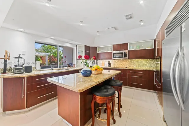 a kitchen with stainless steel appliances granite countertop a sink refrigerator and cabinets