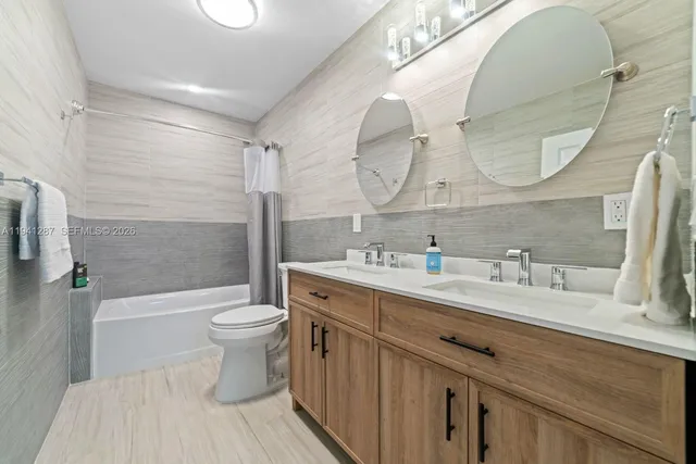 a bathroom with a double vanity sink mirror and toilet