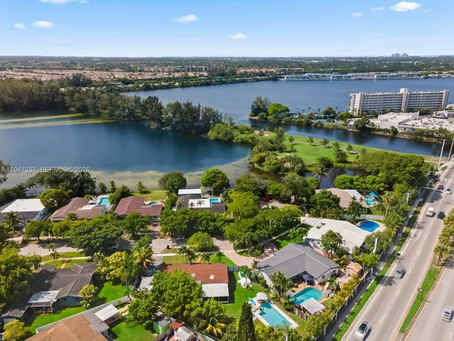an aerial view of residential houses with outdoor space and lake view