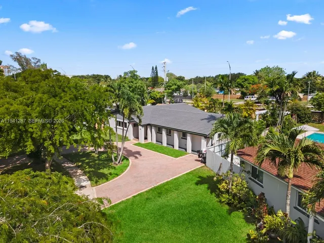 a view of a house with a yard and potted plants