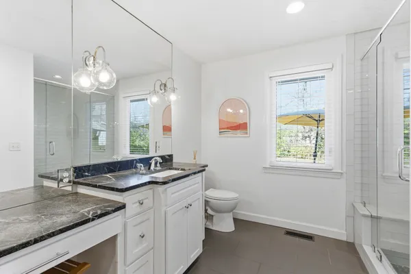 a bathroom with a granite countertop sink a large mirror and a window