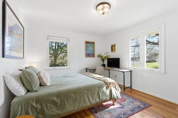 a bedroom with a bed and wooden floor