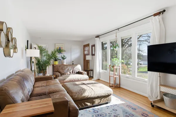a living room with furniture a flat screen tv and a large window