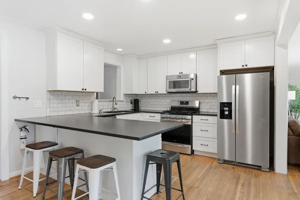 a kitchen with stainless steel appliances a refrigerator stove microwave and cabinets