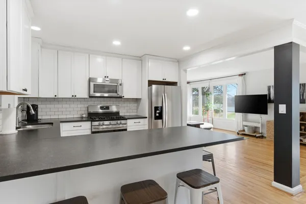 a kitchen with stainless steel appliances a stove a sink a microwave a refrigerator and cabinets