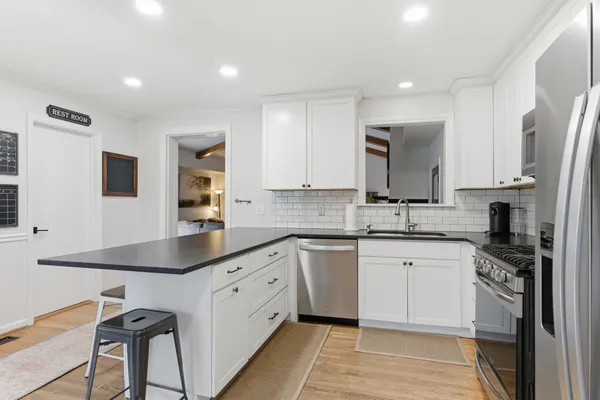a kitchen with stainless steel appliances granite countertop a sink a stove a refrigerator and cabinets