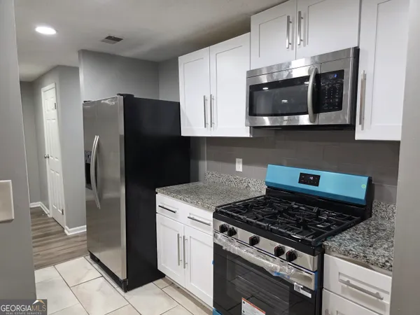 a kitchen with stainless steel appliances granite countertop a refrigerator and a stove