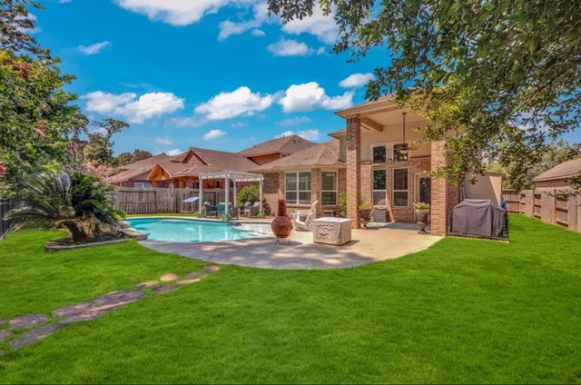 a view of a house with backyard and sitting area
