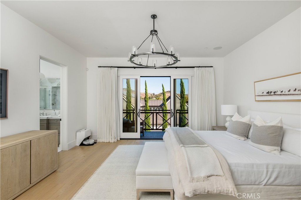 28750 Martingale Drive San Juan Capistrano, CA 92675 - Photo 18 of 45 a bedroom with a large bed and a chandelier