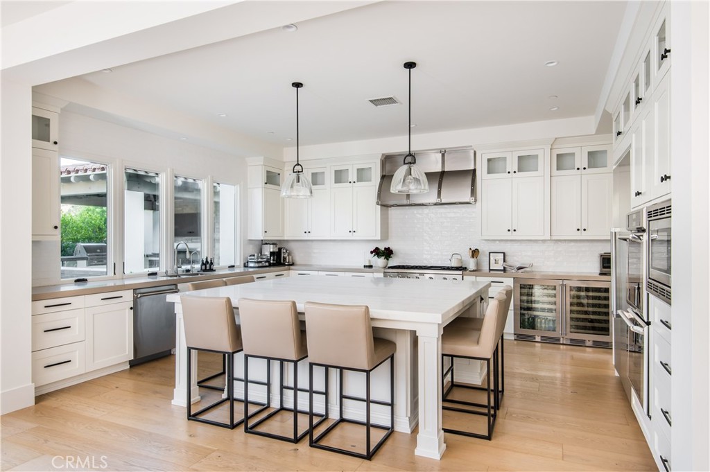 28750 Martingale Drive San Juan Capistrano, CA 92675 - Photo 8 of 45 a kitchen with stainless steel appliances kitchen island granite countertop a table chairs stove and white cabinets