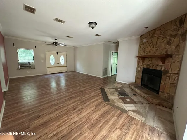 a view of empty room with wooden floor and fireplace