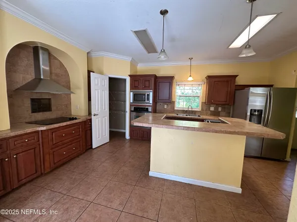 a kitchen with stainless steel appliances granite countertop a stove a sink a refrigerator and a oven