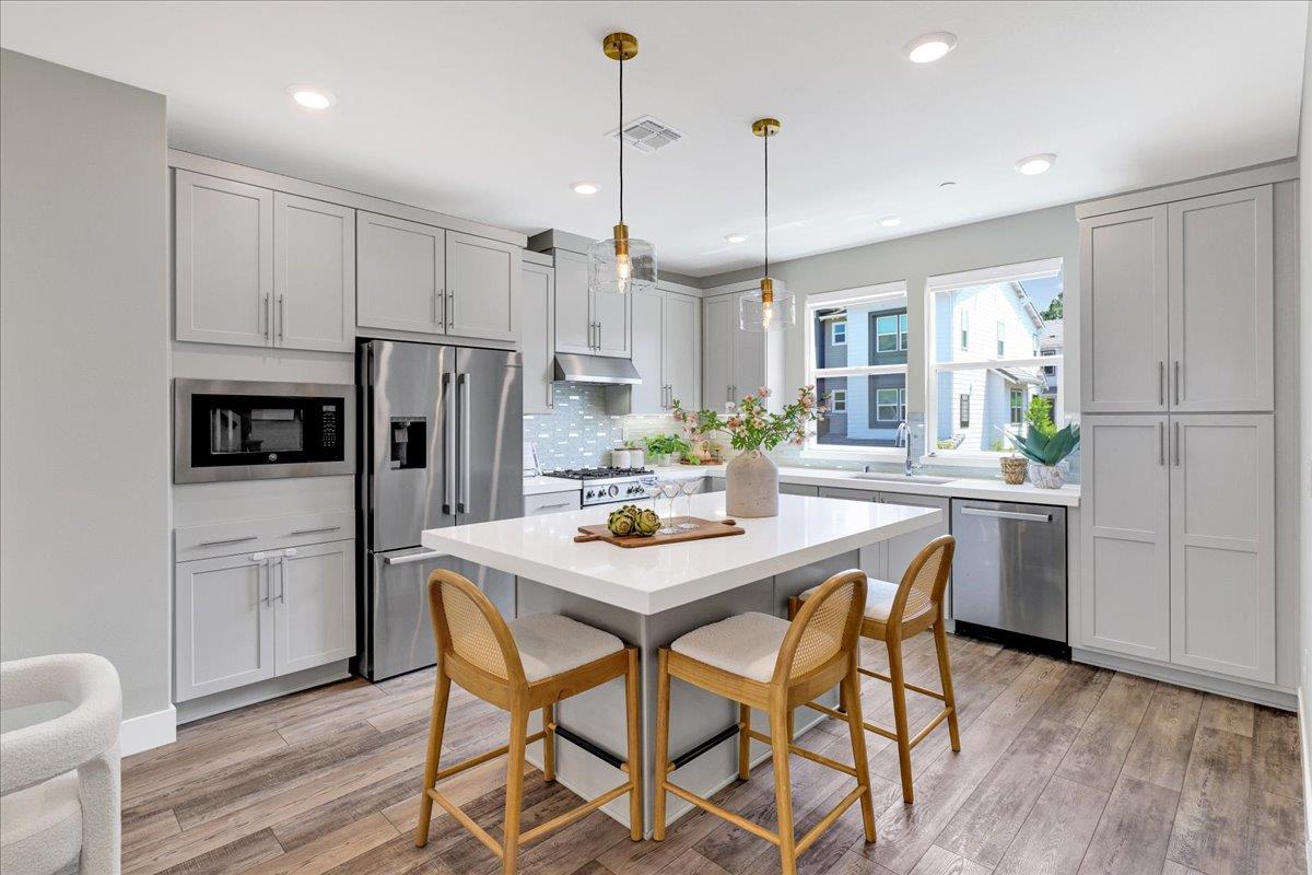 122 Ranch Lane Mountain View, CA 94040 - Photo 21 of 69 a kitchen with stainless steel appliances a dining table chairs refrigerator and microwave