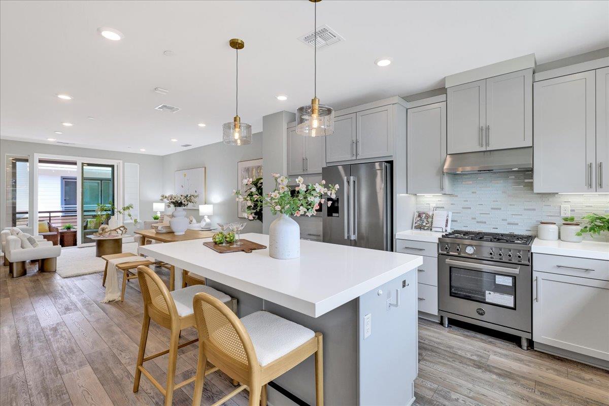 122 Ranch Lane Mountain View, CA 94040 - Photo 25 of 69 a kitchen with stainless steel appliances granite countertop a stove a refrigerator a kitchen island a dining table and chairs with wooden floor