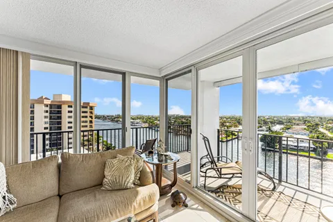 a living room with furniture and floor to ceiling windows