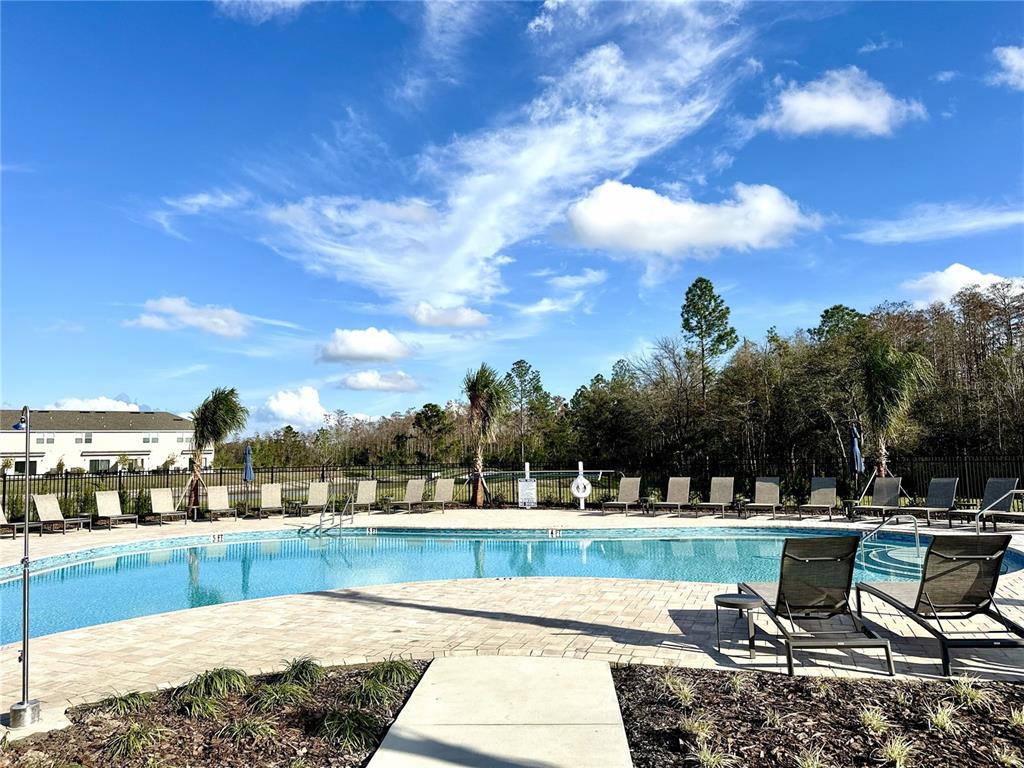 3244 Skyline Loop Kissimmee, FL 34758 - Photo 11 of 13 a swimming pool with outdoor seating and a yard