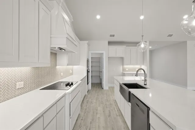 a kitchen with kitchen island white cabinets and stainless steel appliances