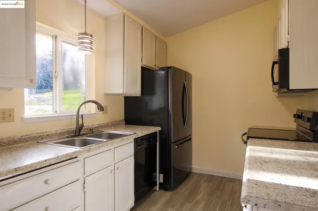 a kitchen with stainless steel appliances granite countertop a refrigerator and a sink