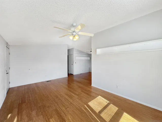 an empty room with wooden floor and window