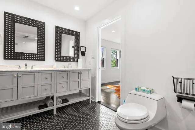 a bathroom with a granite countertop toilet sink and mirror