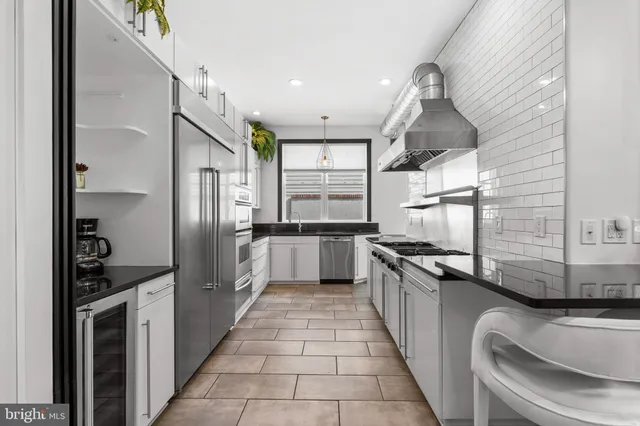 a kitchen with stainless steel appliances granite countertop a sink and a stove