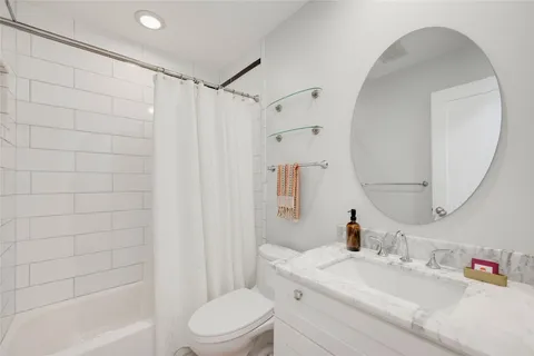a bathroom with a sink a toilet and shower curtain