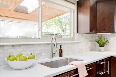 a kitchen with a sink a faucet a potted plant and a window