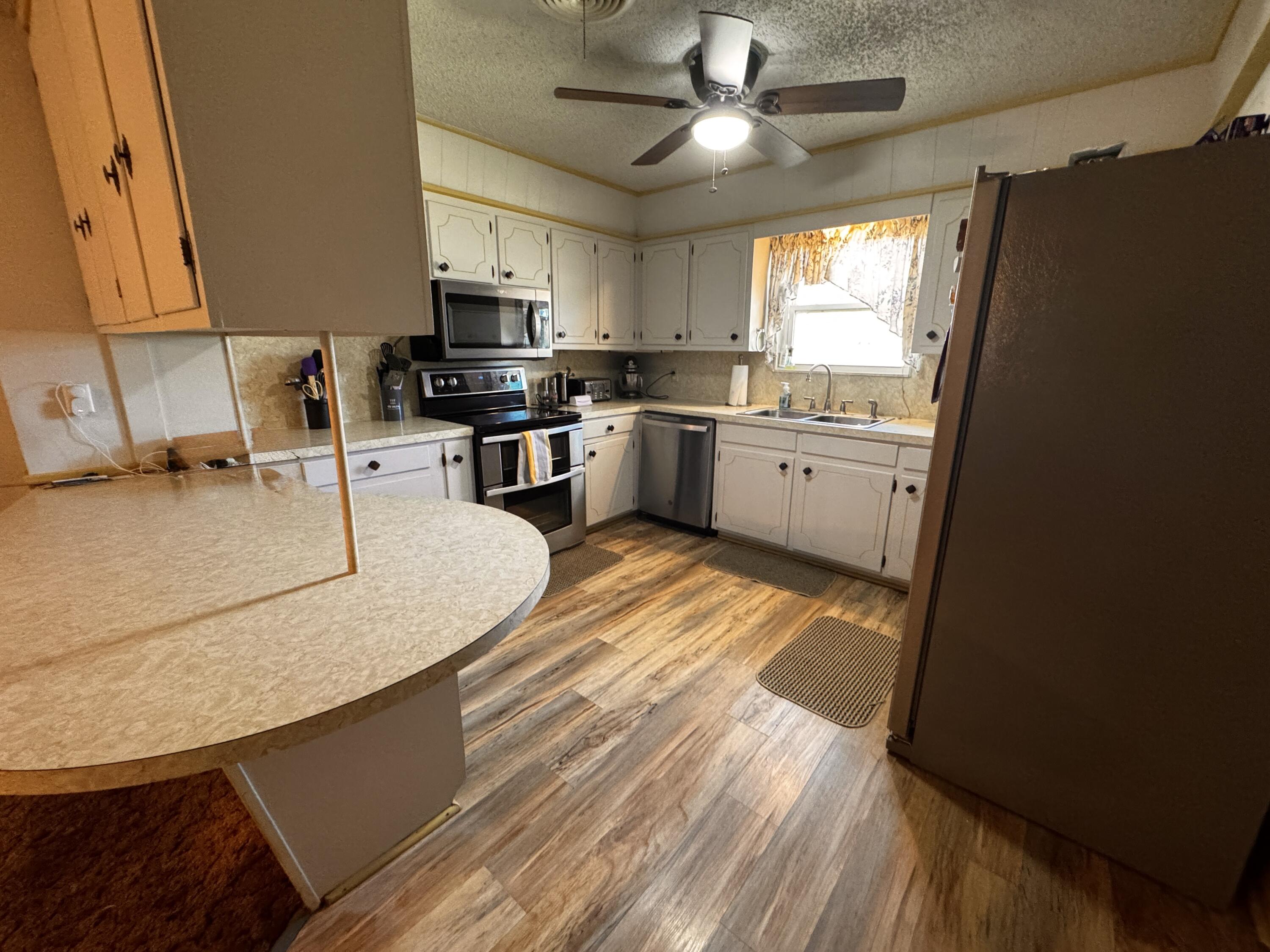 1720 Canyon Plainview, TX 79072 - Photo 18 of 49 a kitchen with granite countertop a sink appliances cabinets and a counter top space