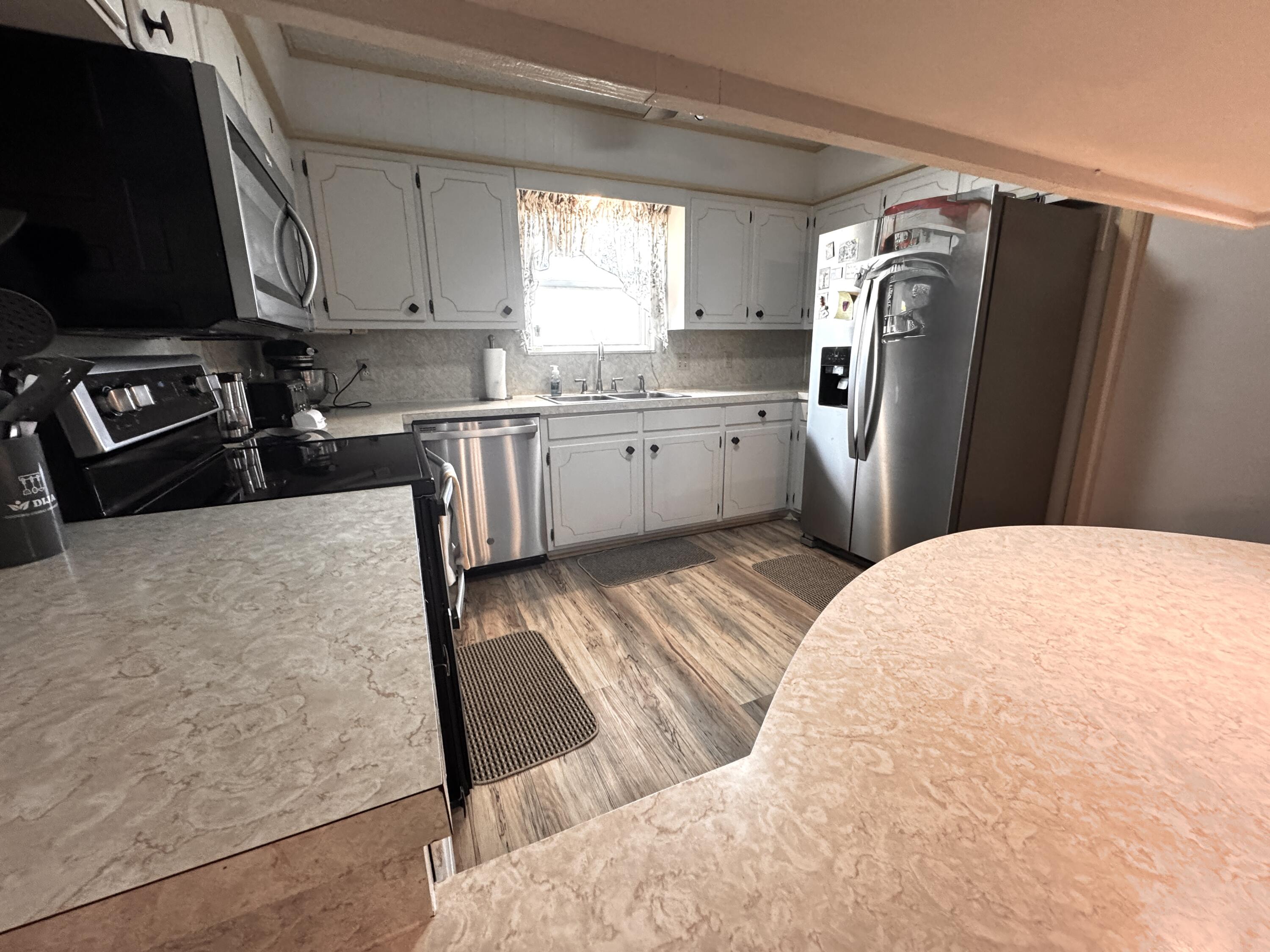 1720 Canyon Plainview, TX 79072 - Photo 20 of 49 a kitchen with stainless steel appliances granite countertop a refrigerator a stove a sink and a microwave