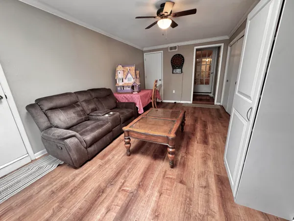 a living room with furniture and a wooden floor