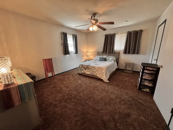 a spacious bedroom with a bed and a dresser in it