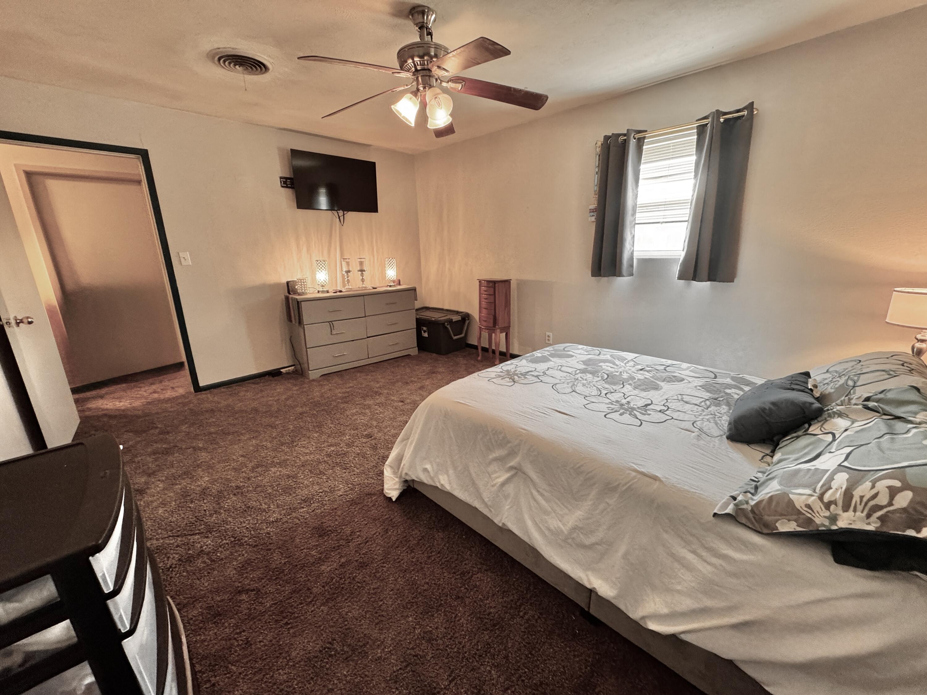 1720 Canyon Plainview, TX 79072 - Photo 36 of 49 a bedroom with a bed and a chandelier