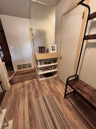 a view of an empty room with furniture wooden floor and window