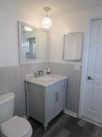 a bathroom with a granite countertop sink toilet and shower