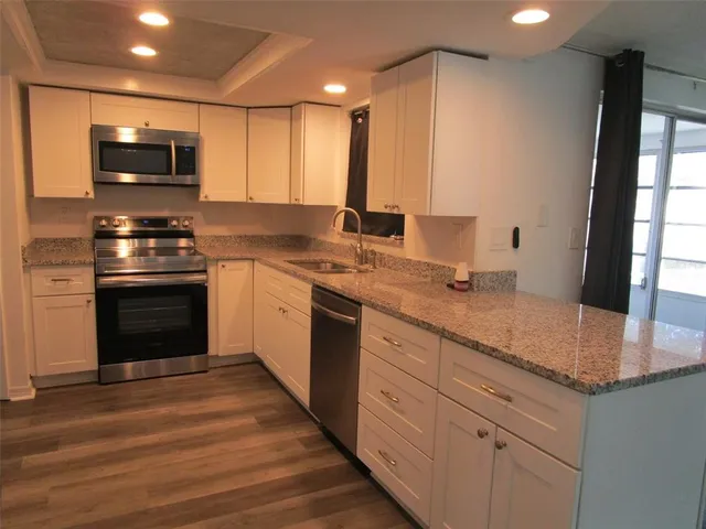 a kitchen with a sink stove and microwave