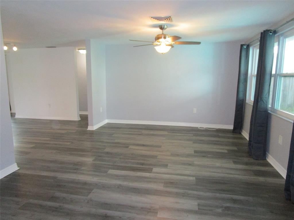 7226 San Moritz Drive Port Richey, FL 34668 - Photo 8 of 38 wooden floor in an empty room with a mirror