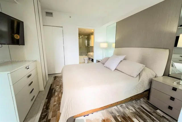 a bedroom with a bed and a flat screen tv