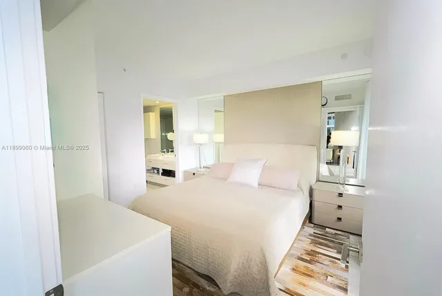 a white bed sitting in a bedroom next to a window