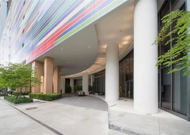 a front view of a house with a yard and potted plants