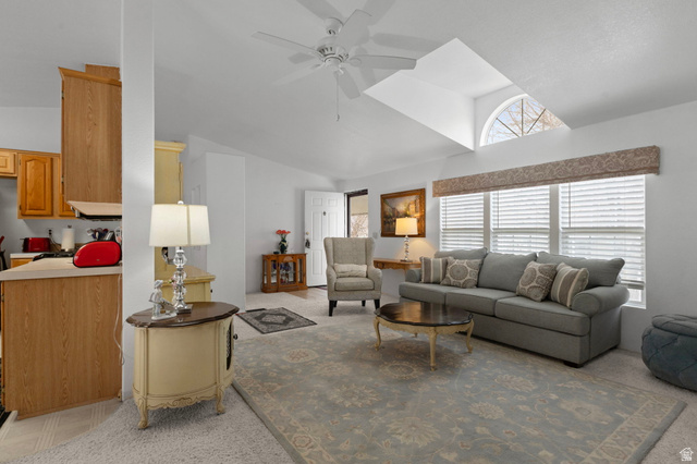 2600 North Hill Field Road, Unit 134 Layton, UT 84041 - Photo 8 of 41 Living area with ceiling fan, vaulted ceiling, and light colored carpet
