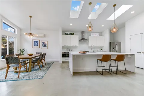 a kitchen with a dining table chairs and white cabinets