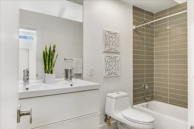 a bathroom with a toilet a sink a mirror and shower